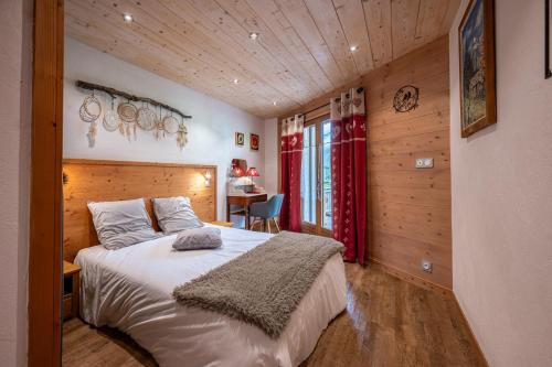 a bedroom with a bed in a room with wooden walls at Gîte L'attrape Rêves in Bessans