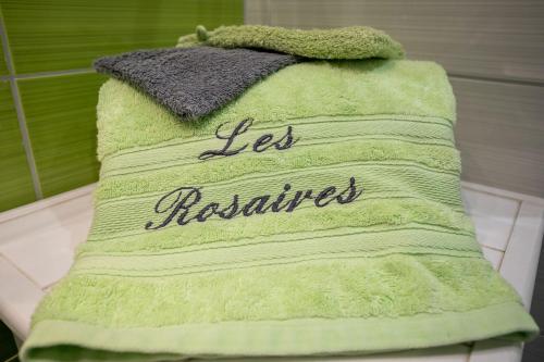 a green towel with the words less resilient on it at Appartement en front de mer in Plérin