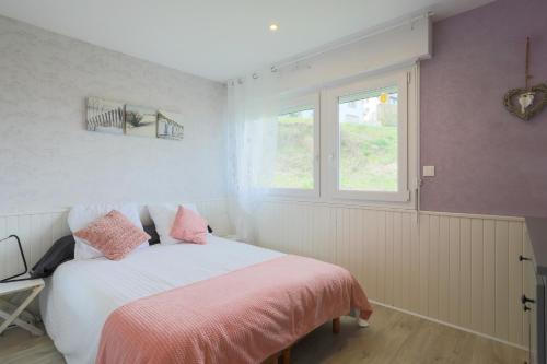 a bedroom with a bed with pink sheets and a window at Appartement en front de mer in Plérin