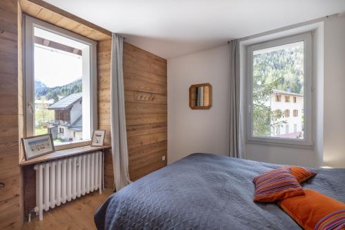 a bedroom with a bed and two large windows at Chalet La Llyre Vallorcine in Vallorcine