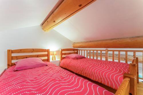 two twin beds in a bedroom with pink sheets at Chambre Laurier Rose in Piolenc