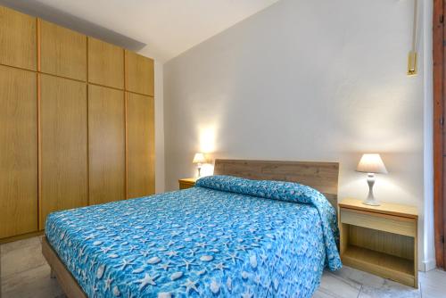 a bedroom with a bed with a blue comforter at Casa Claudia a Porto Azzurro in Porto Azzurro