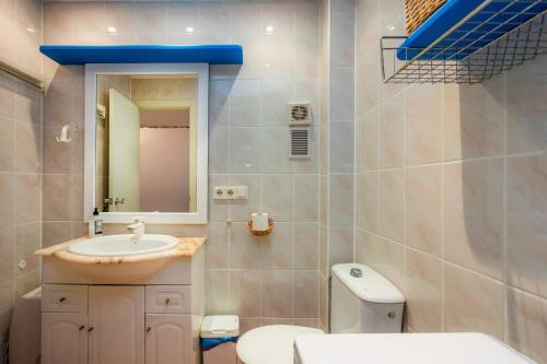 a bathroom with a sink and a toilet and a mirror at Ferrera Suite in Cala Ferrera