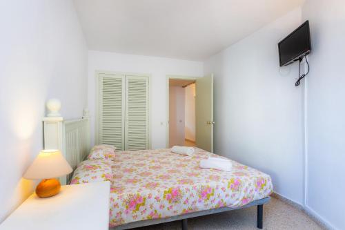 a bedroom with a bed and a tv on a wall at Ferrera Suite in Cala Ferrera
