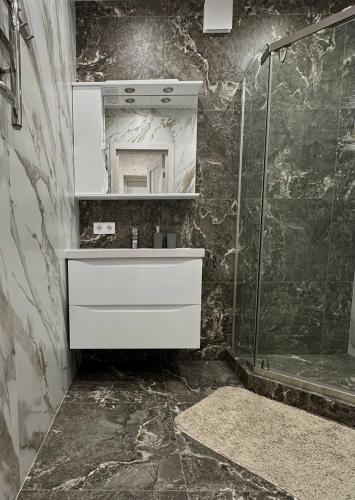 a bathroom with a white sink and a shower at Harmony Cottage in Kyiv