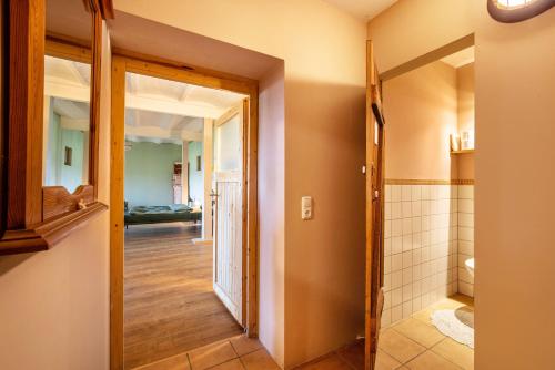 ein Flur mit einer Tür, die zu einem Badezimmer führt in der Unterkunft Studiowohnung To Huus in Tappendorf