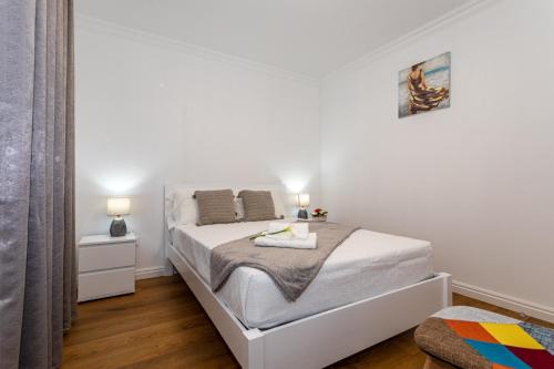 a white bedroom with a bed in a room at Oásis Fonte Grande in Santo António