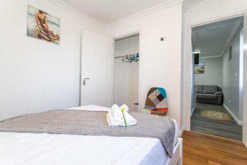 a white bedroom with a bed and a chair at Oásis Fonte Grande in Santo António