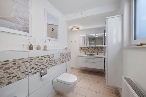 a white bathroom with a toilet and a sink at Ferienwohnung Mayer in Albstadt