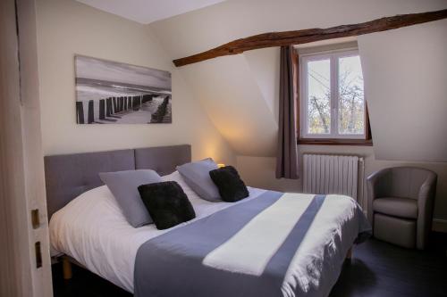 a bedroom with a large bed and a window at Chambres D'hôtes Le Petit Puits in Cheverny
