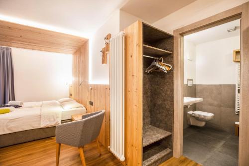 a bedroom with a bed and a bathroom with a toilet at Chalet Osmar Suite 2 in Campitello di Fassa
