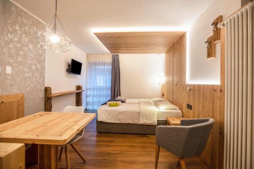 a bedroom with a bed and a table and a dining room at Chalet Osmar Suite 2 in Campitello di Fassa
