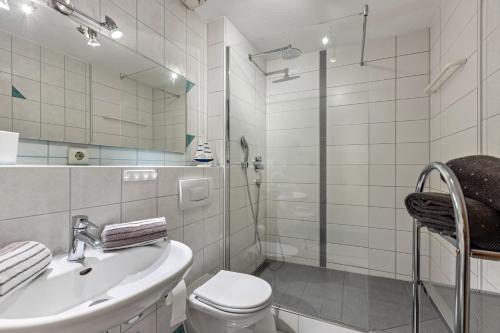 a bathroom with a toilet and a sink and a shower at Ferienwohnung Heilsbergblick in Hilzingen