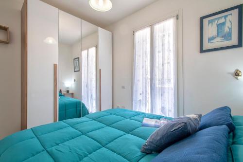 a blue bed in a room with a large window at Ad occhi aperti - Castelsardo in Castelsardo