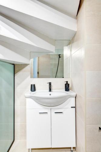 a bathroom with a sink and a mirror at VICE by Apiro Syros in Ermoupoli