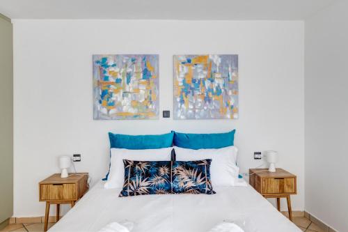 a bedroom with a white bed with two tables at VICE by Apiro Syros in Ermoupoli