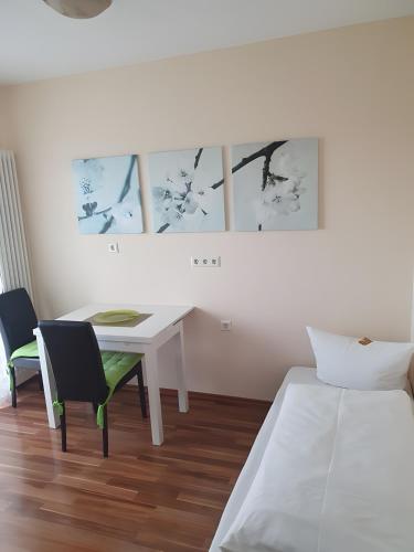 a white room with a table and chairs and a bed at Hotel Sonnenhof in Illertissen