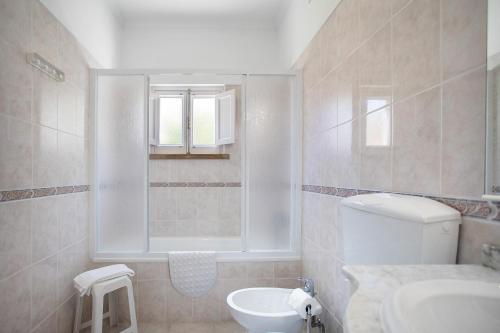 a bathroom with a toilet and a sink and a window at Páteo da Várzea 4 in Colares