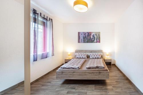 a bedroom with a bed and two lamps in it at Ferienwohnung Sonnenberg in Degerfelden