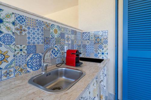 a kitchen with a sink and blue and white tiles at Melus Maris in Syracuse