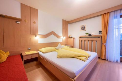 a bedroom with a bed with yellow pillows at Niederkoflhof Durreck in Cadipietra