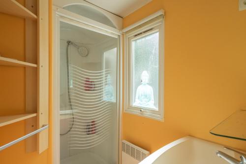 a bathroom with a shower and a tub and a window at Mh 61 La Tremblade in La Tremblade
