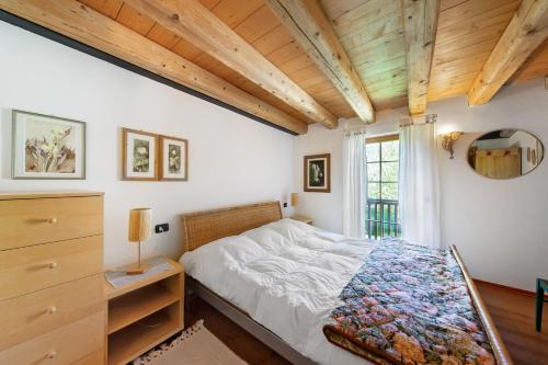 a bedroom with a bed and a dresser and a window at Villa Cleila Verde B in San Vito di Cadore