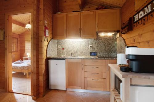 a kitchen with wooden cabinets and a sink in a cabin at Quinta Do Castelo - Casa de Madeira in Reguengo Grande