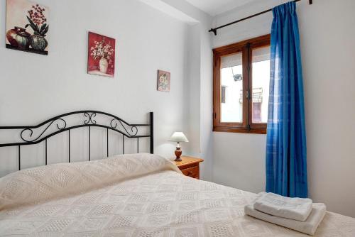 a bedroom with a white bed and a window at Casa Ángela in Conil de la Frontera