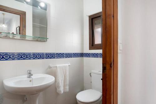 a white bathroom with a sink and a toilet at Casa Ángela in Conil de la Frontera