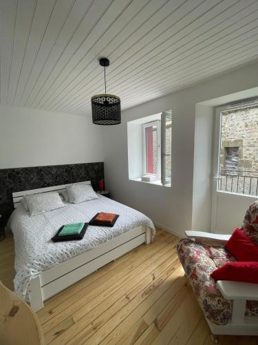 a white bedroom with a bed and a couch at Maison de campagne in Séneujols