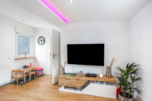 a living room with a flat screen tv on a wall at Ferienwohnung Kurparkblicksauerland in Lennestadt
