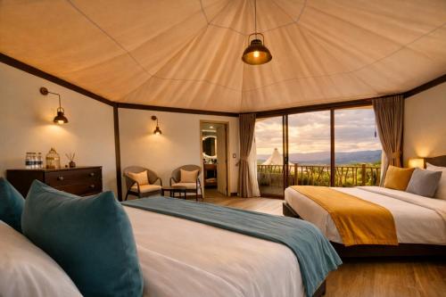 a bedroom with two beds and a view of the ocean at Hemma Genki Luxury Wellness Hotel Villa in Villa de Leyva