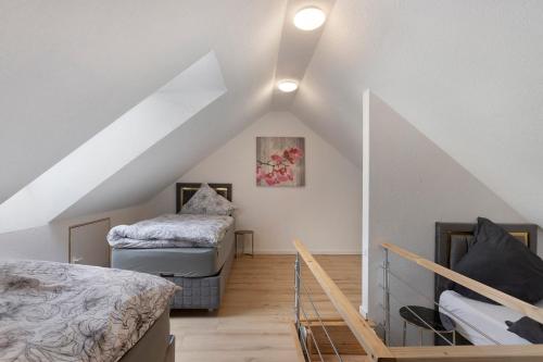 a attic room with two beds and a staircase at Fewo Mca in Rielasingen-Worblingen