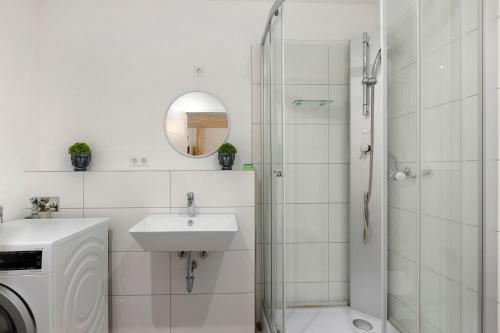 a white bathroom with a sink and a shower at Fewo Mca in Rielasingen-Worblingen
