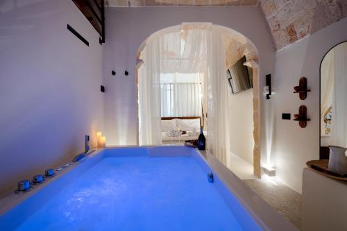a large blue swimming pool in a room with a window at Archè Luxury private Spa in Polignano a Mare