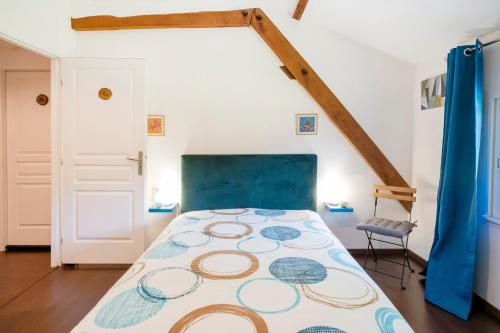 a bedroom with a bed with a blue head board at Chambre Chene in Mauléon-dʼArmagnac