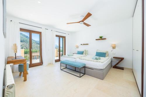 a white bedroom with a bed and a balcony at Sa Papaiona in Valldemossa