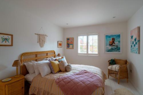 a bedroom with a bed and a window at Surfers Roost in Croyde