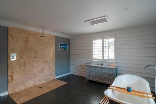 a bathroom with a tub and a sink at Surfers Roost in Croyde