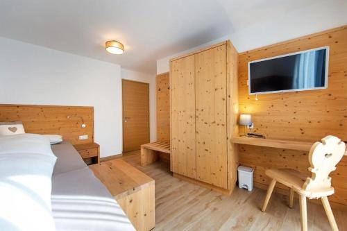 a bedroom with a bed and a desk and a tv at Gass Apartment B in Laion