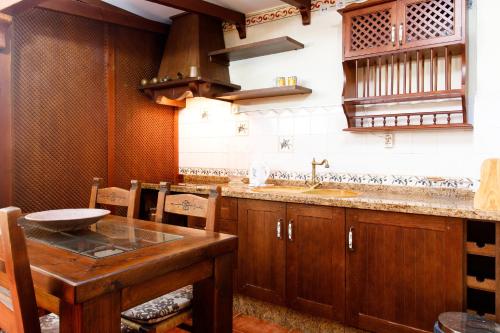 a kitchen with a wooden table and a sink at Villa Palomas in Nerja