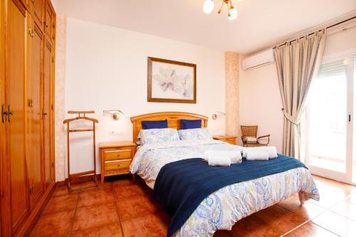 a bedroom with a bed with a blue comforter at Villa Palomas in Nerja