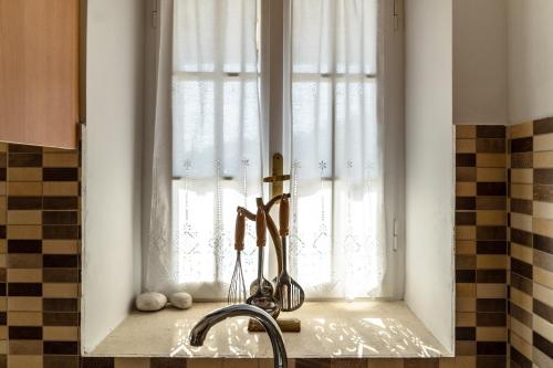 a window in a kitchen with scissors on a counter at Afroksilia Villa Gardenia in Lefkada