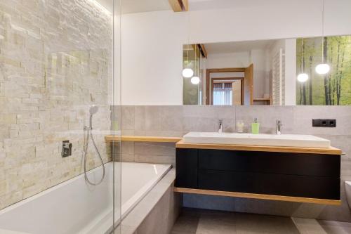 a bathroom with a sink and a shower and a tub at Angerle Alm Apt Alpenglühen in Carezza al Lago