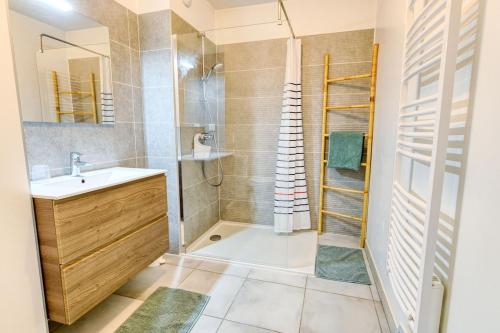 a bathroom with a shower and a sink and a mirror at Senyo Cocoon in Seignosse