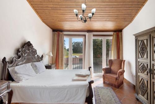 a bedroom with a bed and a chair and a window at Casa de Barqueiros in Barqueiros
