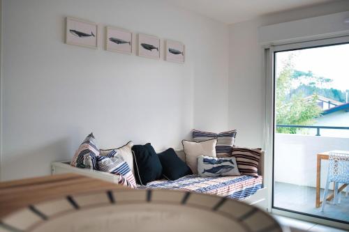 a living room with a couch and a sliding glass door at Senyo Cocoon in Seignosse