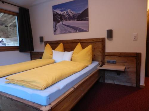 a bedroom with two beds with yellow pillows at Haus Alpenflora in Flirsch