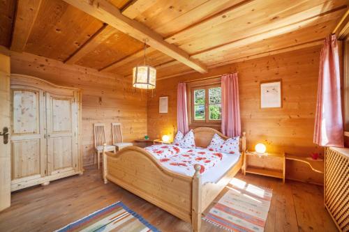 a bedroom with a bed in a wooden house at Ferienhaus Rauchegg - Seeblick in San Pancrazio dʼUltimo